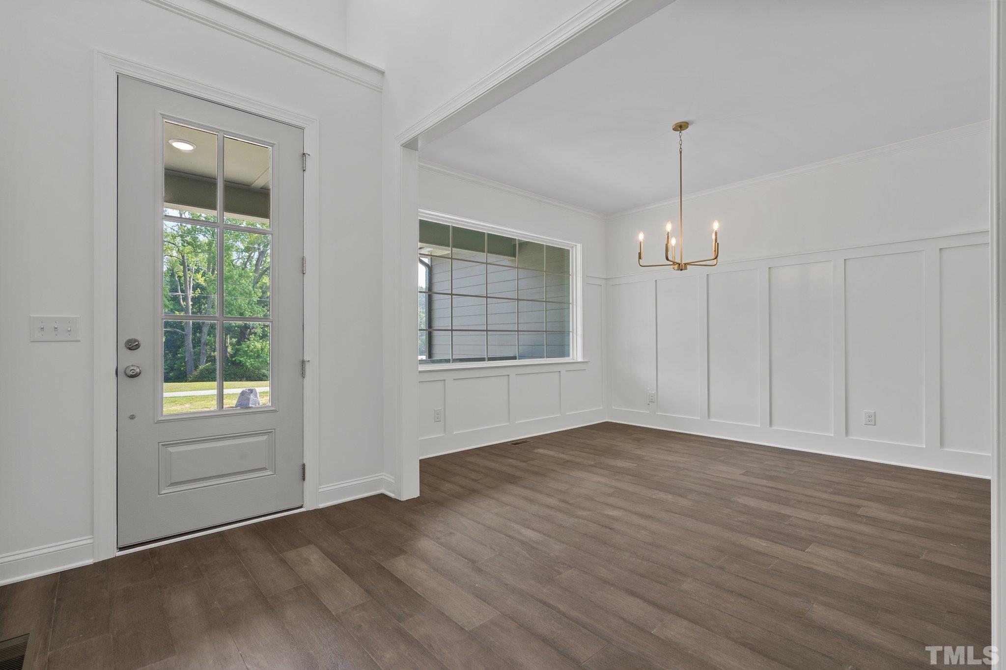 488 Pine Ridge Road Zebulon, NC 27597 - Photo 18 of 47 an empty room with wooden floor cabinet and windows