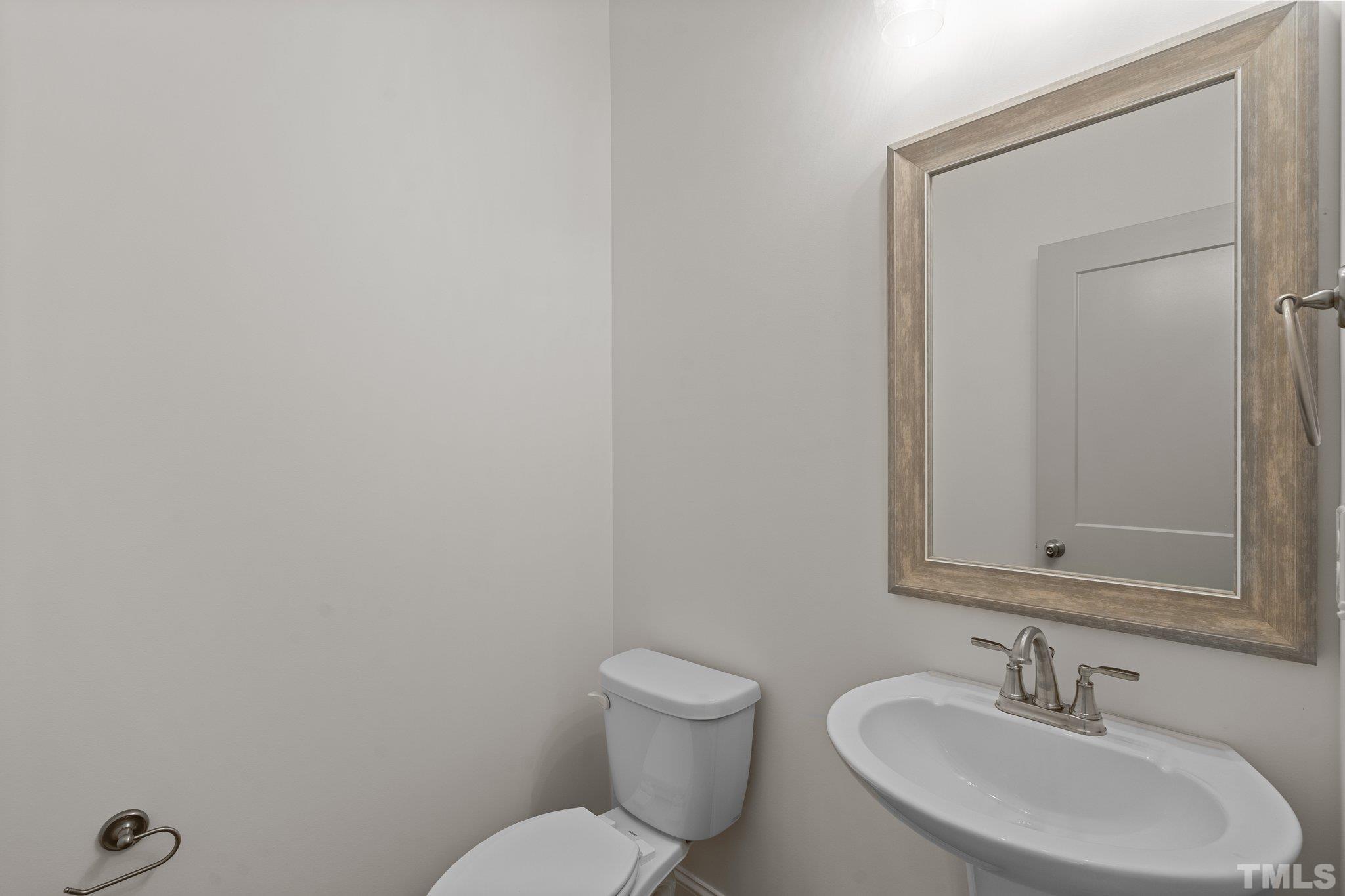 488 Pine Ridge Road Zebulon, NC 27597 - Photo 22 of 47 a bathroom with a toilet a sink and mirror