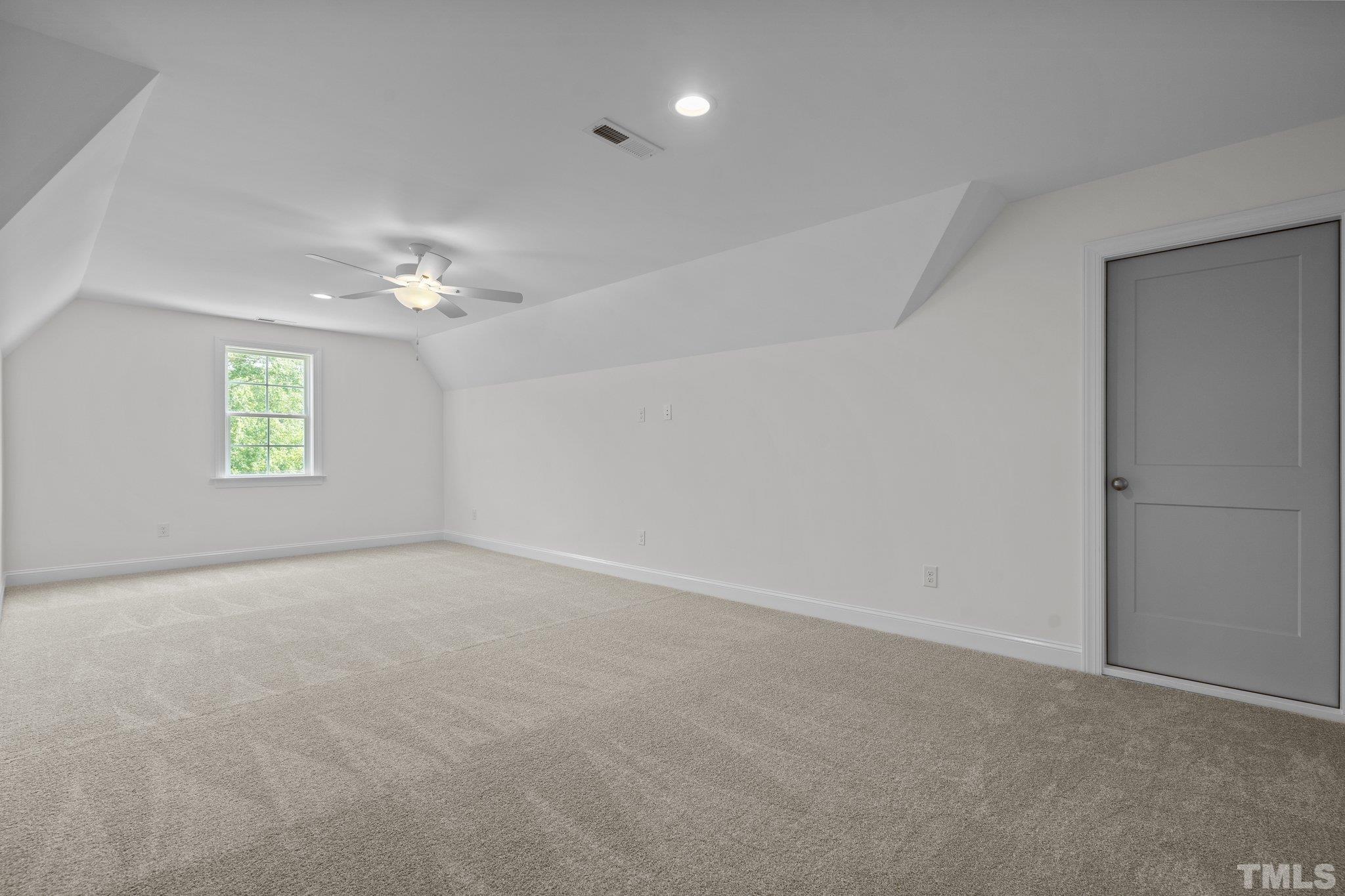 488 Pine Ridge Road Zebulon, NC 27597 - Photo 25 of 47 an empty room with windows and chandelier fan