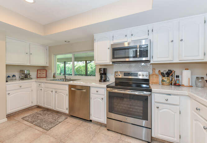 493 Forestview Drive Atlantis, FL 33462 - Photo 13 of 27 a kitchen with granite countertop cabinets stainless steel appliances and a window