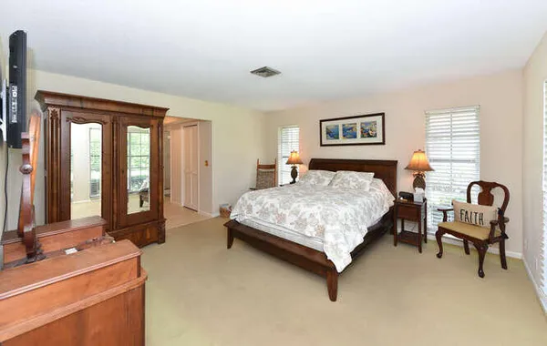 a bedroom with a bed chair and window