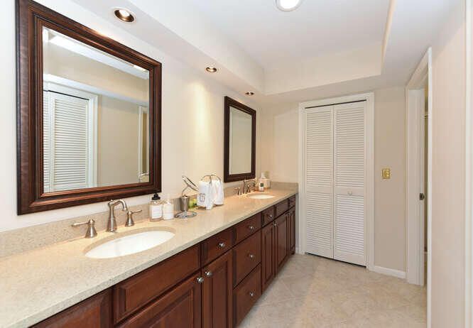 493 Forestview Drive Atlantis, FL 33462 - Photo 21 of 27 a bathroom with double vanity sinks and a mirror