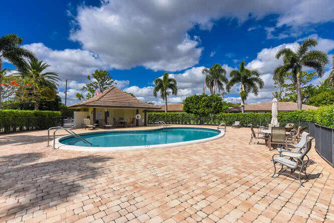 493 Forestview Drive Atlantis, FL 33462 - Photo 26 of 27 a view of a swimming pool with lawn chairs and a fire pit