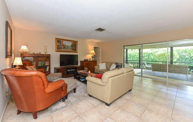 493 Forestview Drive Atlantis, FL 33462 - Photo 10 of 27 a living room with furniture and a flat screen tv