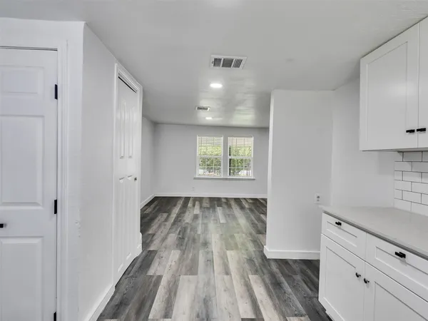 a view of a kitchen with wooden floor and electronic appliances