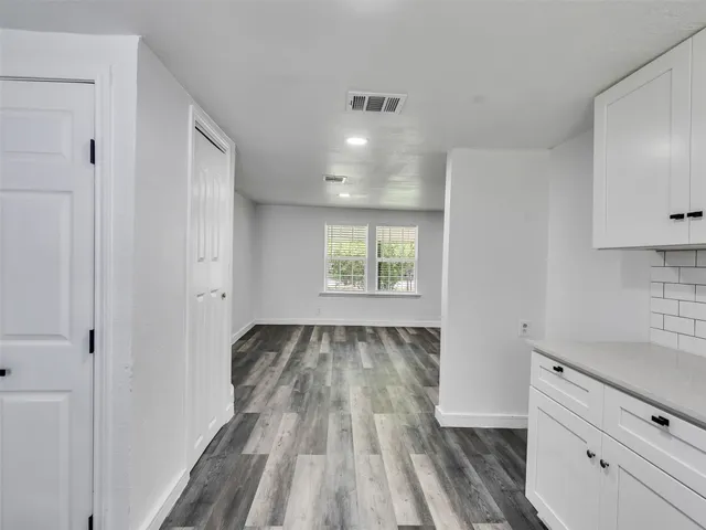 a view of a kitchen with wooden floor and electronic appliances