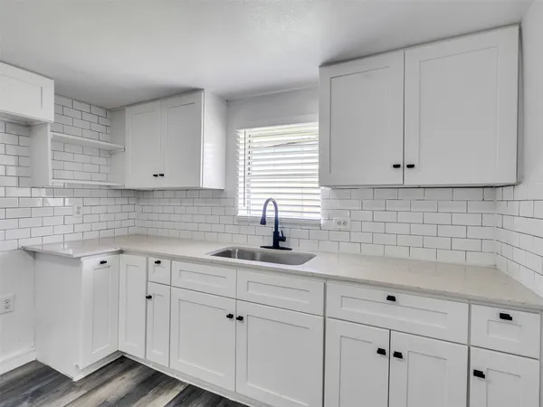 a kitchen with white cabinets white appliances and sink