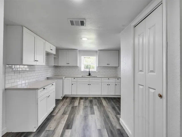 a kitchen with granite countertop white cabinets and white appliances