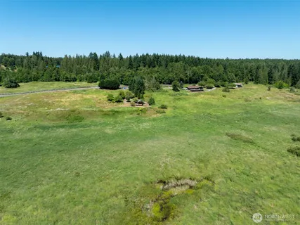a view of a field with trees in the background
