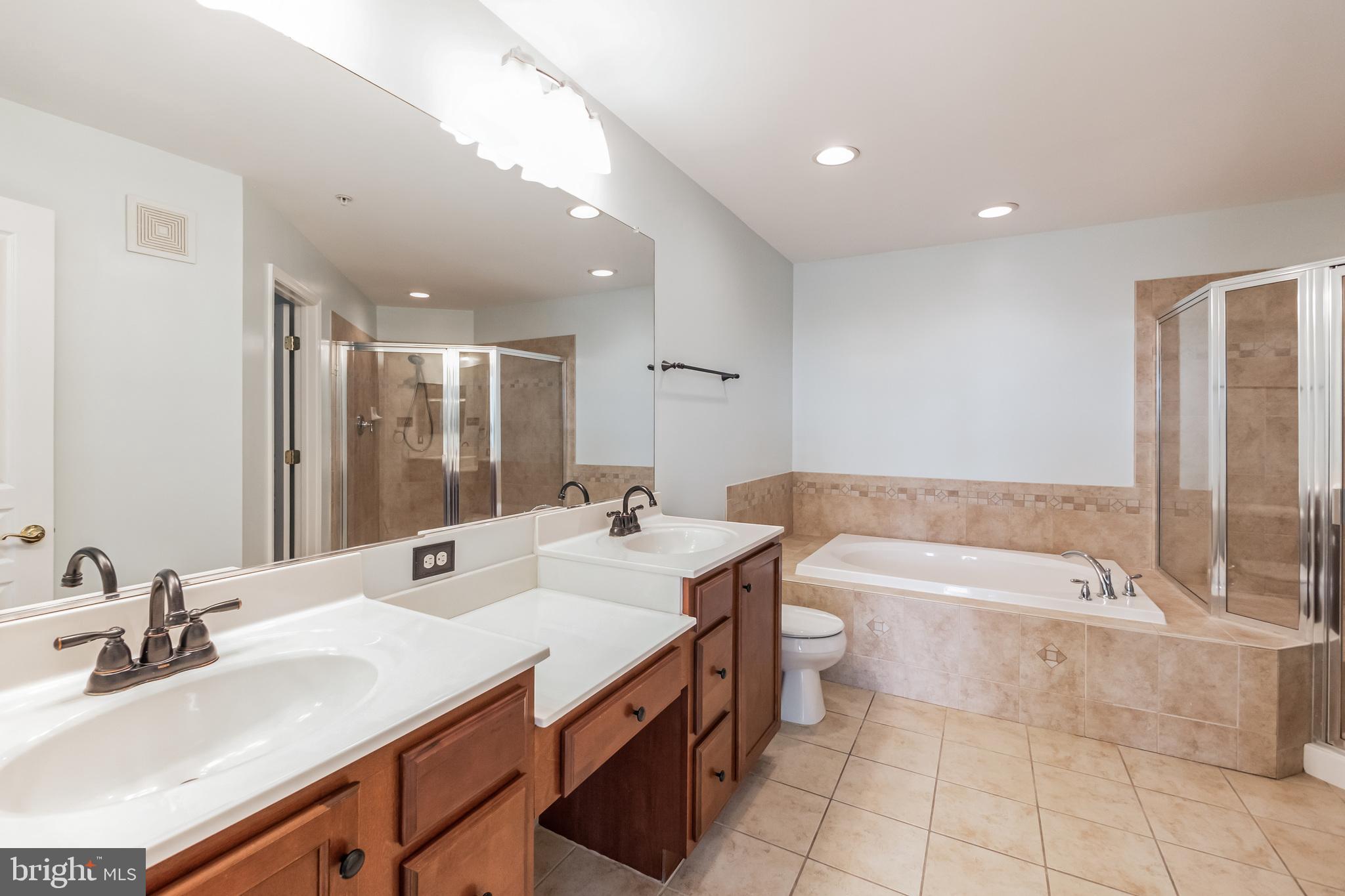 1834 Monocacy View Circle, Unit 53B Frederick, MD 21701 - Photo 17 of 30 a bathroom with a double vanity sink toilet mirror and bathtub
