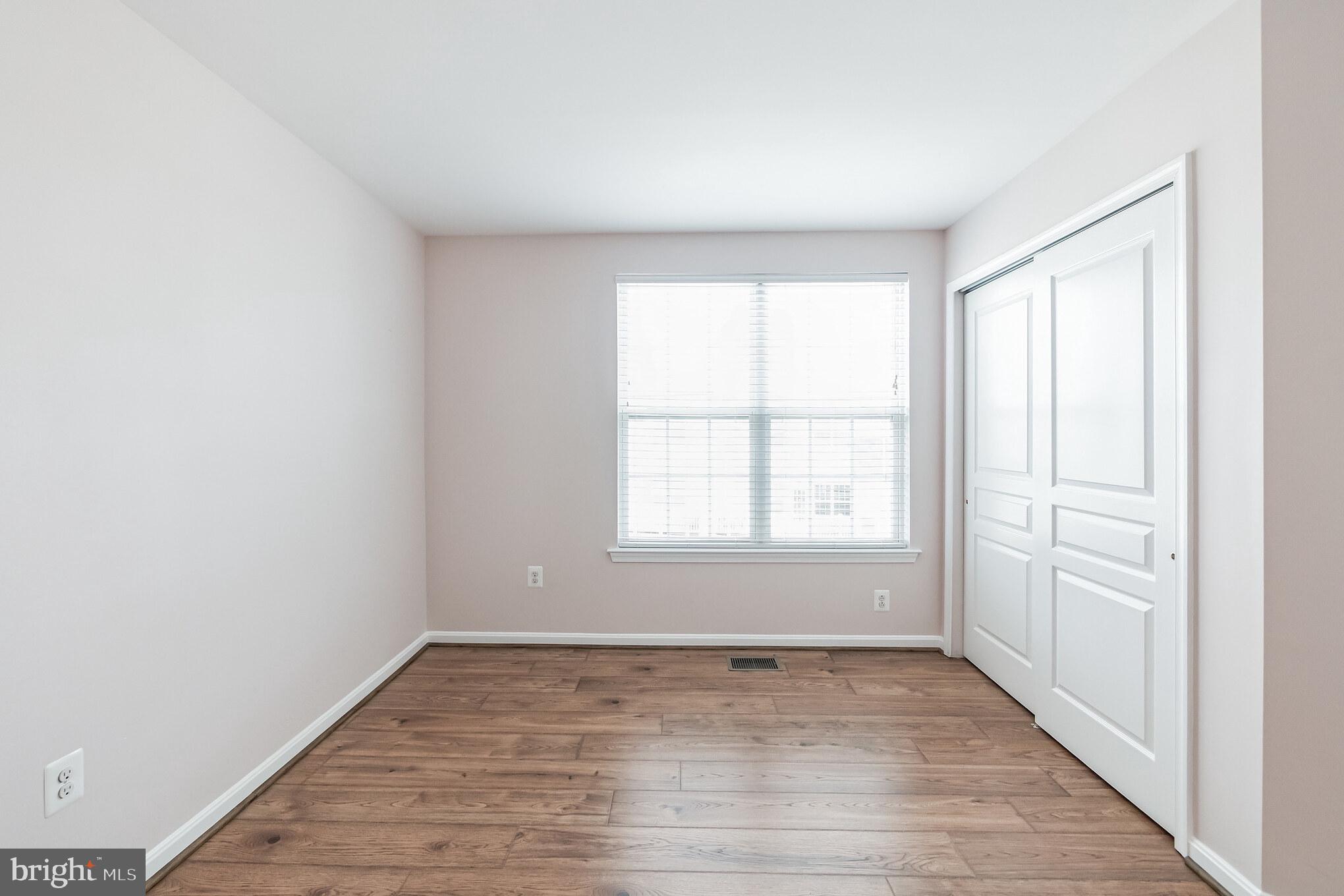 1834 Monocacy View Circle, Unit 53B Frederick, MD 21701 - Photo 24 of 30 an empty room with wooden floor and windows