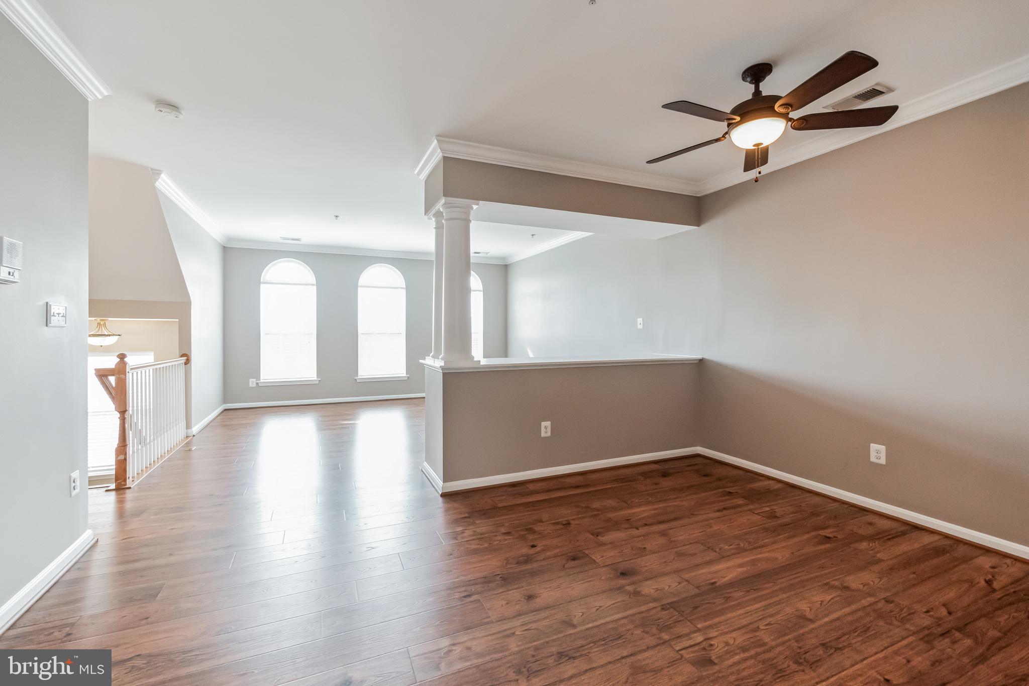 1834 Monocacy View Circle, Unit 53B Frederick, MD 21701 - Photo 5 of 30 a view of an empty room with wooden floor and a ceiling fan