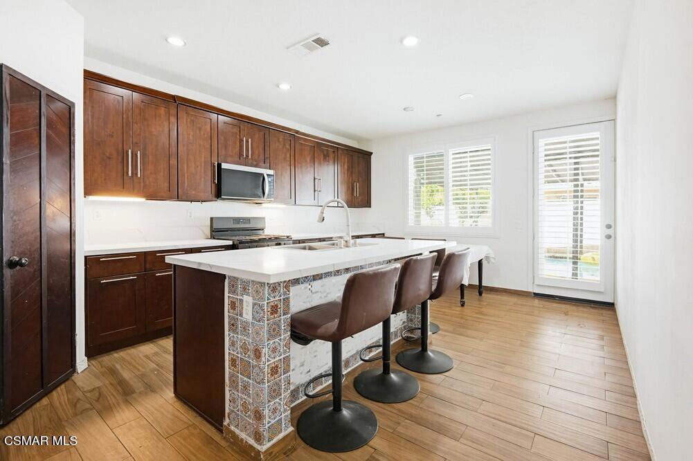 1909 Taormina Court Riverside, CA 92507 - Photo 12 of 58 a kitchen with a sink cabinets and wooden floor