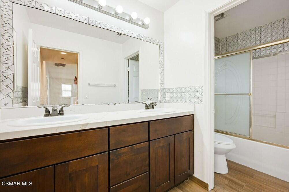 1909 Taormina Court Riverside, CA 92507 - Photo 31 of 58 a bathroom with a double vanity sink toilet and a mirror