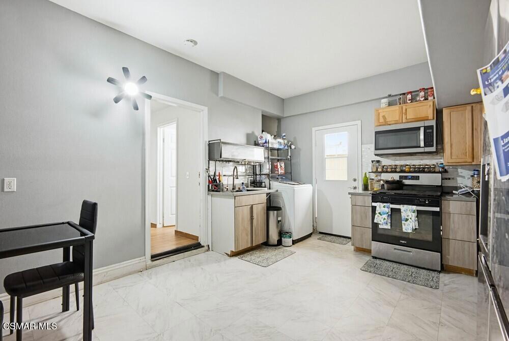 1909 Taormina Court Riverside, CA 92507 - Photo 37 of 58 a kitchen with white cabinets and stainless steel appliances