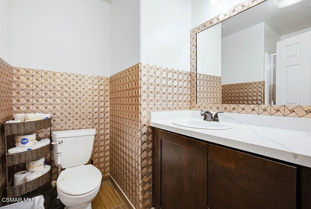 1909 Taormina Court Riverside, CA 92507 - Photo 43 of 58 a bathroom with a granite countertop toilet sink and mirror