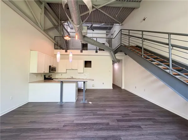 a view of a hallway with wooden floor and staircase