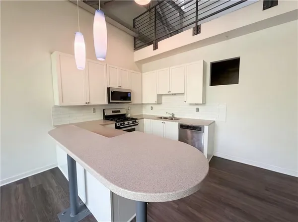 a kitchen with a appliances cabinets and wooden floor