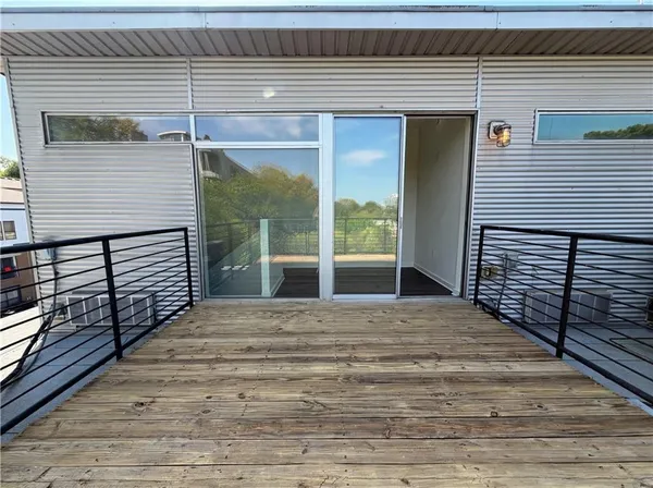 a view of a balcony with wooden floor and fence