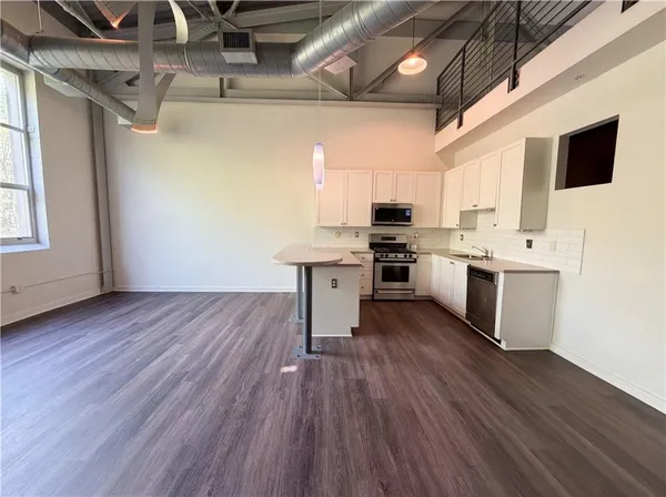 a view of entryway and kitchen with wooden floor