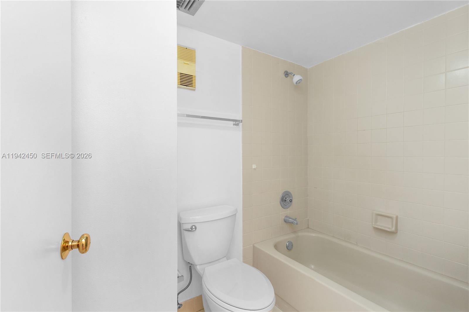 8810 Southwest 132nd Place, Unit 403DN Miami, FL 33186 - Photo 13 of 21 a white toilet sitting next to a bath tub