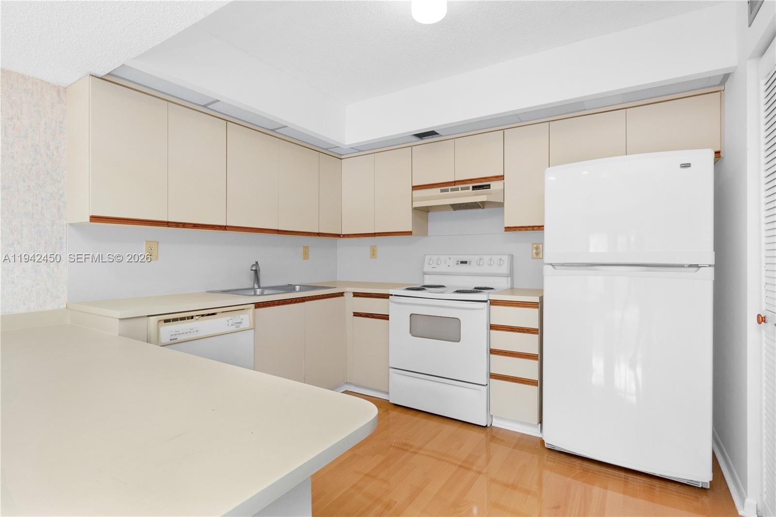 8810 Southwest 132nd Place, Unit 403DN Miami, FL 33186 - Photo 14 of 29 a kitchen with a white cabinets and white appliances