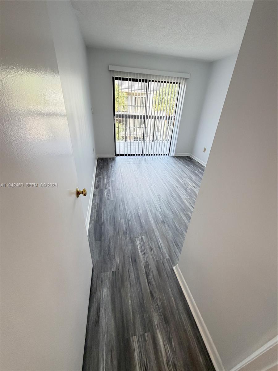 8810 Southwest 132nd Place, Unit 403DN Miami, FL 33186 - Photo 15 of 21 wooden floor in an empty room with a window