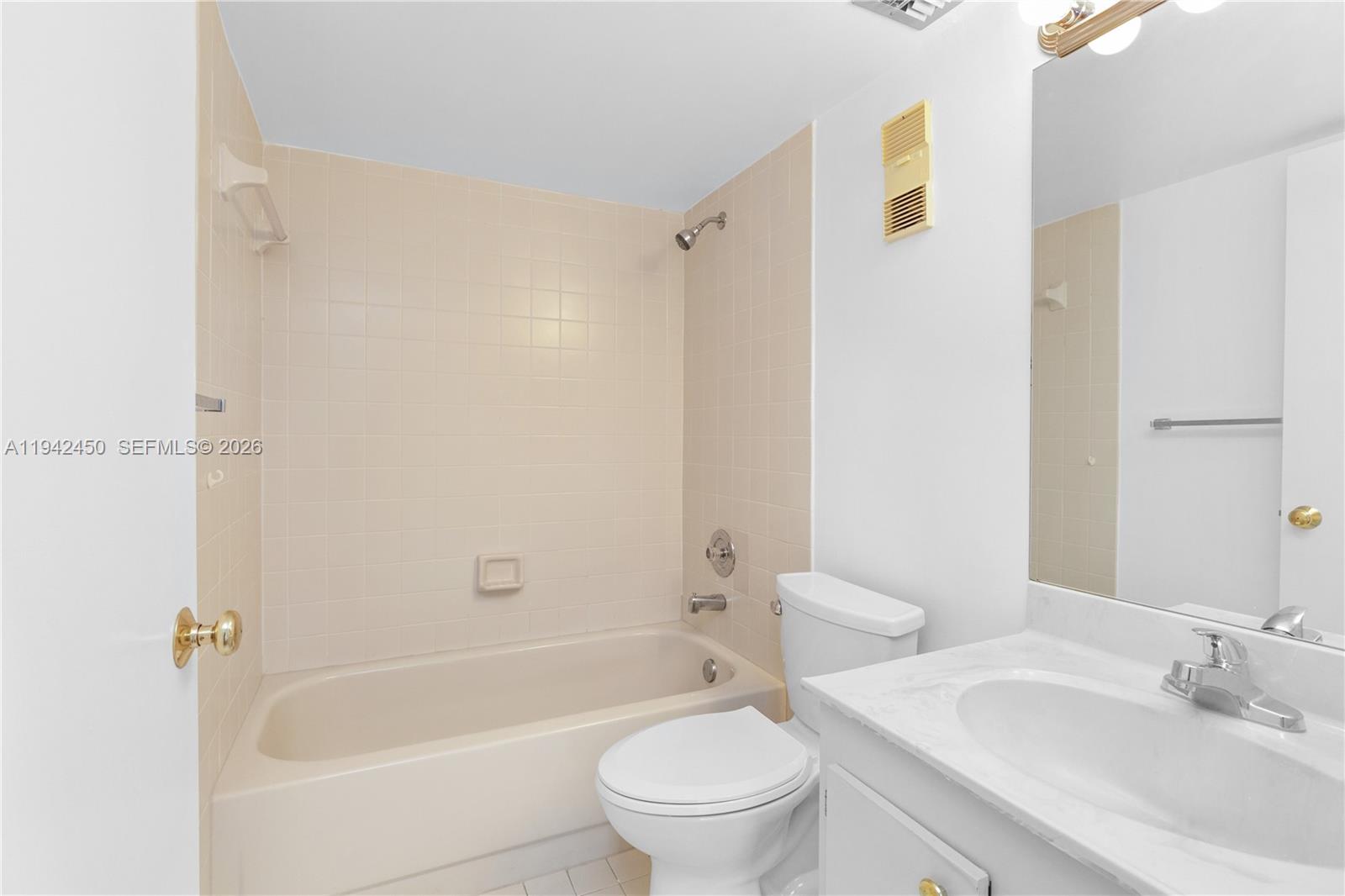 8810 Southwest 132nd Place, Unit 403DN Miami, FL 33186 - Photo 15 of 29 a bathroom with a bathtub shower sink vanity and toilet