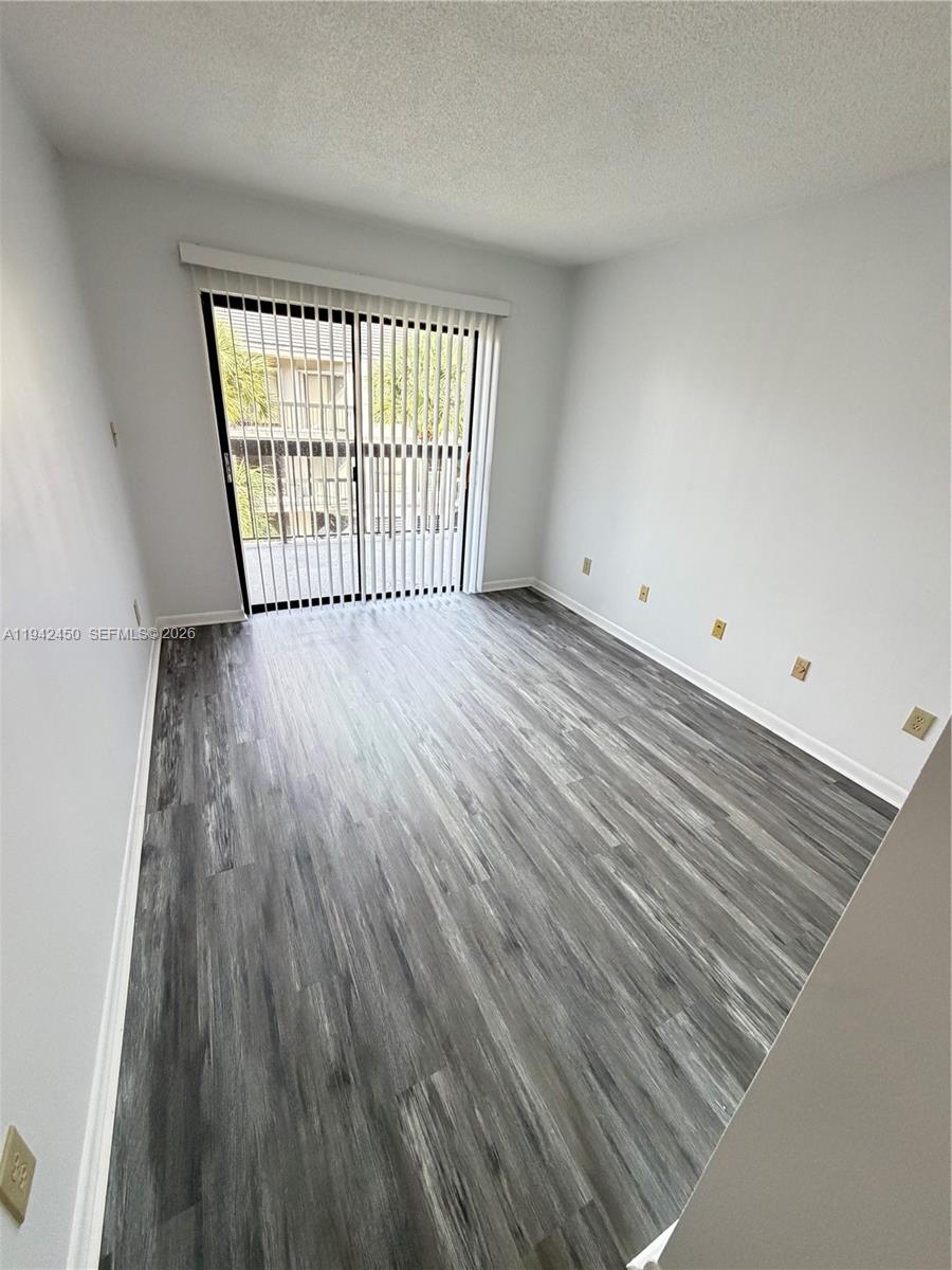 8810 Southwest 132nd Place, Unit 403DN Miami, FL 33186 - Photo 16 of 21 wooden floor in an empty room with a window