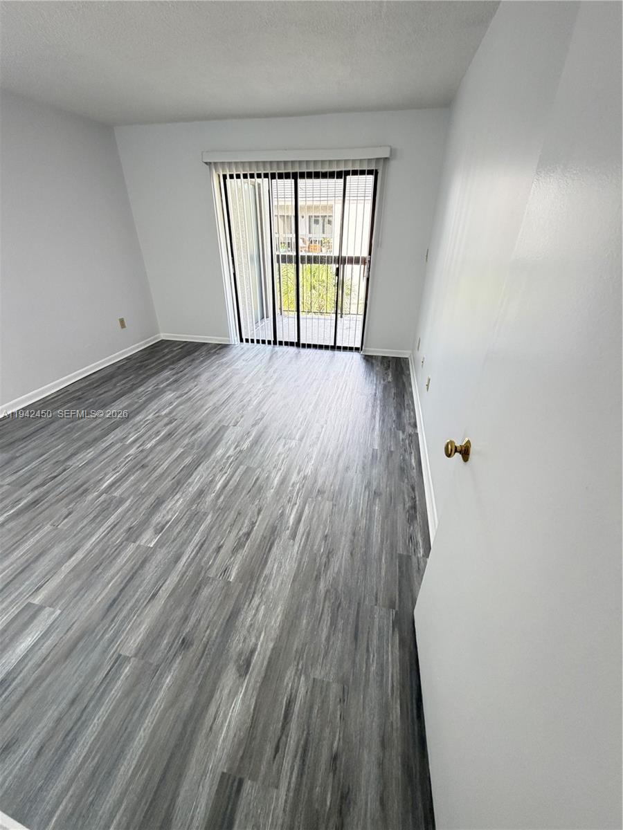 8810 Southwest 132nd Place, Unit 403DN Miami, FL 33186 - Photo 17 of 21 wooden floor in an empty room with a window