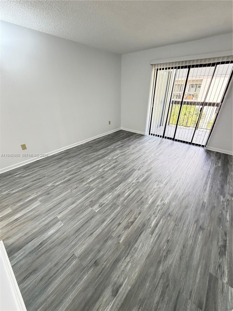 8810 Southwest 132nd Place, Unit 403DN Miami, FL 33186 - Photo 18 of 21 wooden floor in an empty room with a window