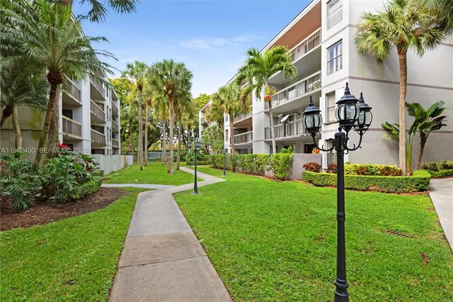 a view of a house with a yard and palm trees