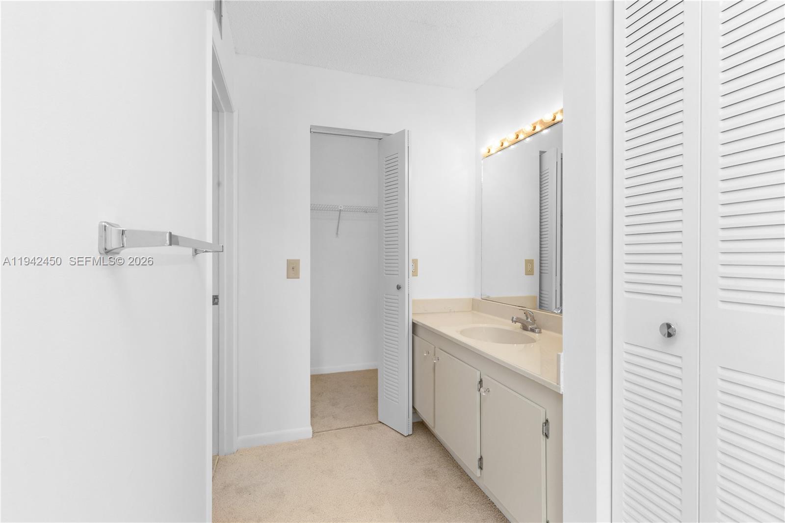 8810 Southwest 132nd Place, Unit 403DN Miami, FL 33186 - Photo 22 of 29 a bathroom with a sink and a mirror