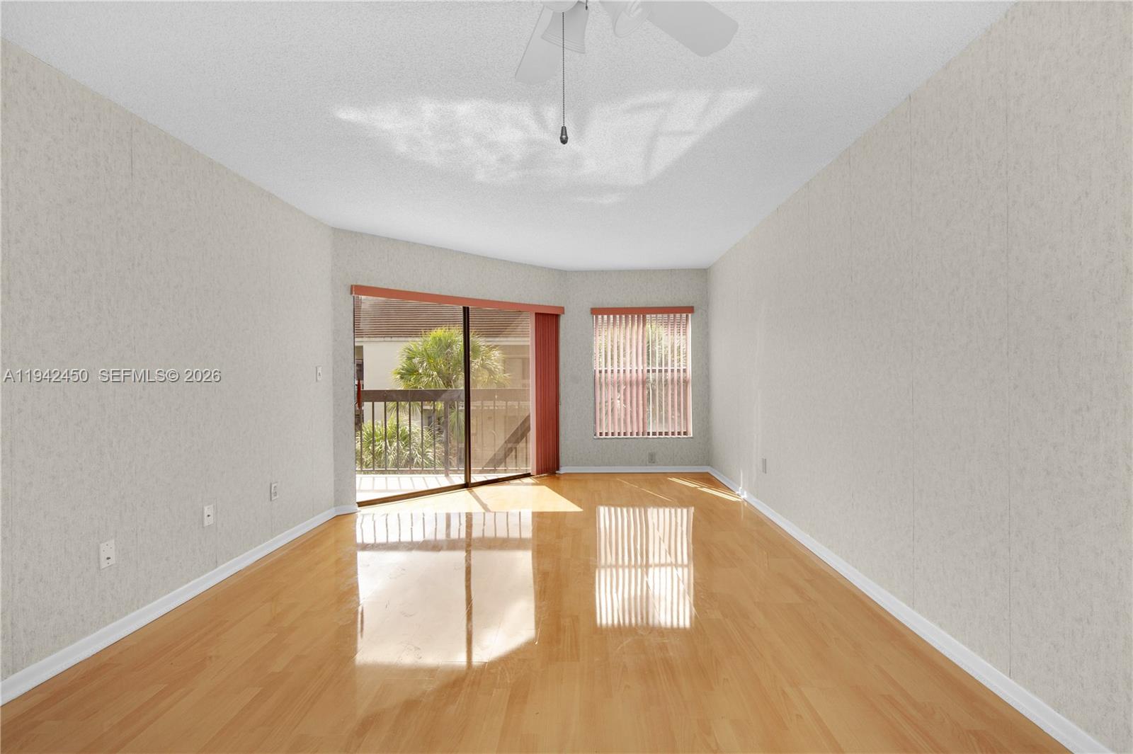 8810 Southwest 132nd Place, Unit 403DN Miami, FL 33186 - Photo 6 of 29 a view of an empty room with wooden floor and a window