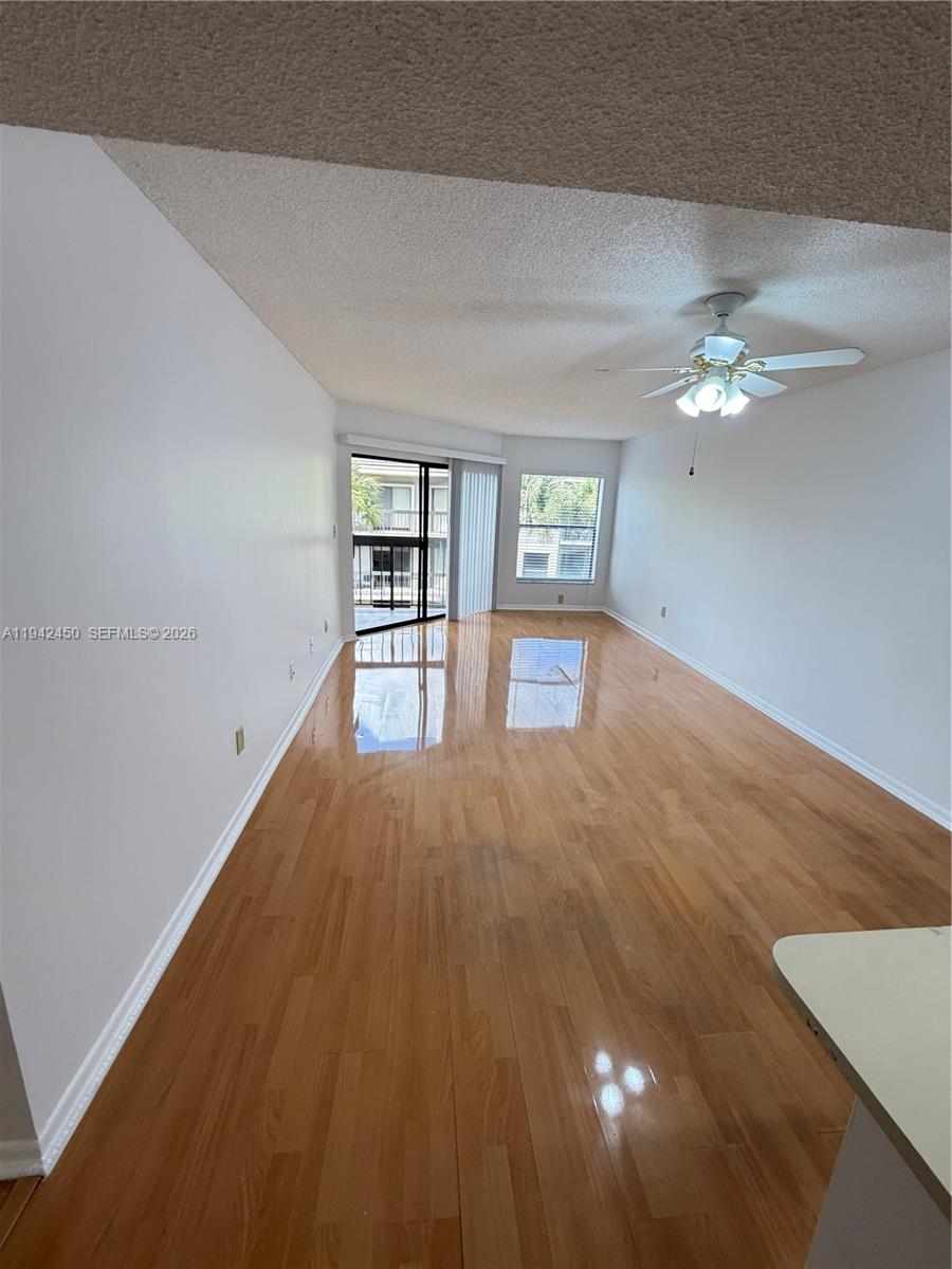 8810 Southwest 132nd Place, Unit 403DN Miami, FL 33186 - Photo 6 of 21 wooden floor in an empty room with a window