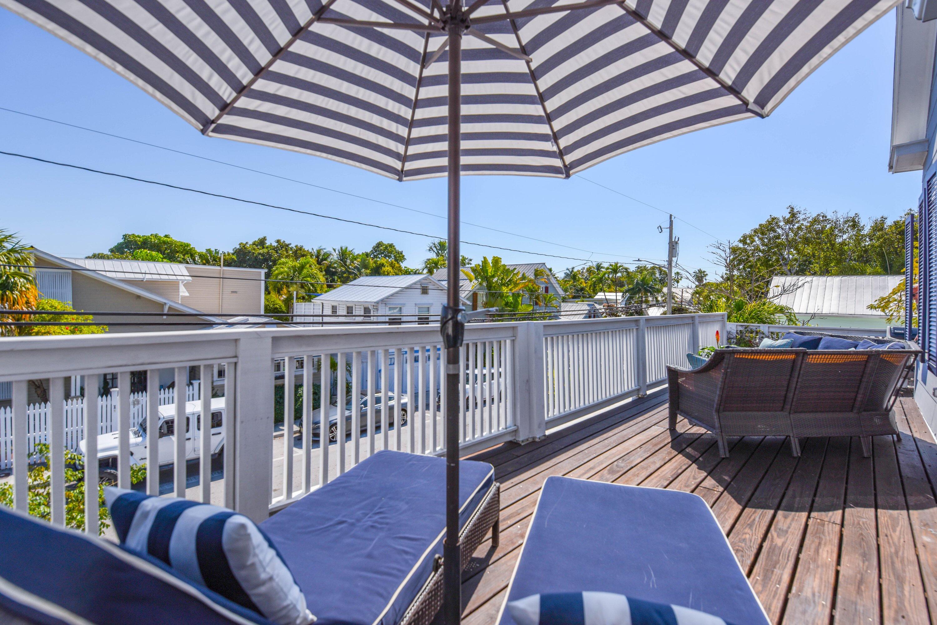 828 White Street, Unit 1 Key West, FL 33040 - Photo 36 of 43 a balcony with wooden floor and outdoor seating