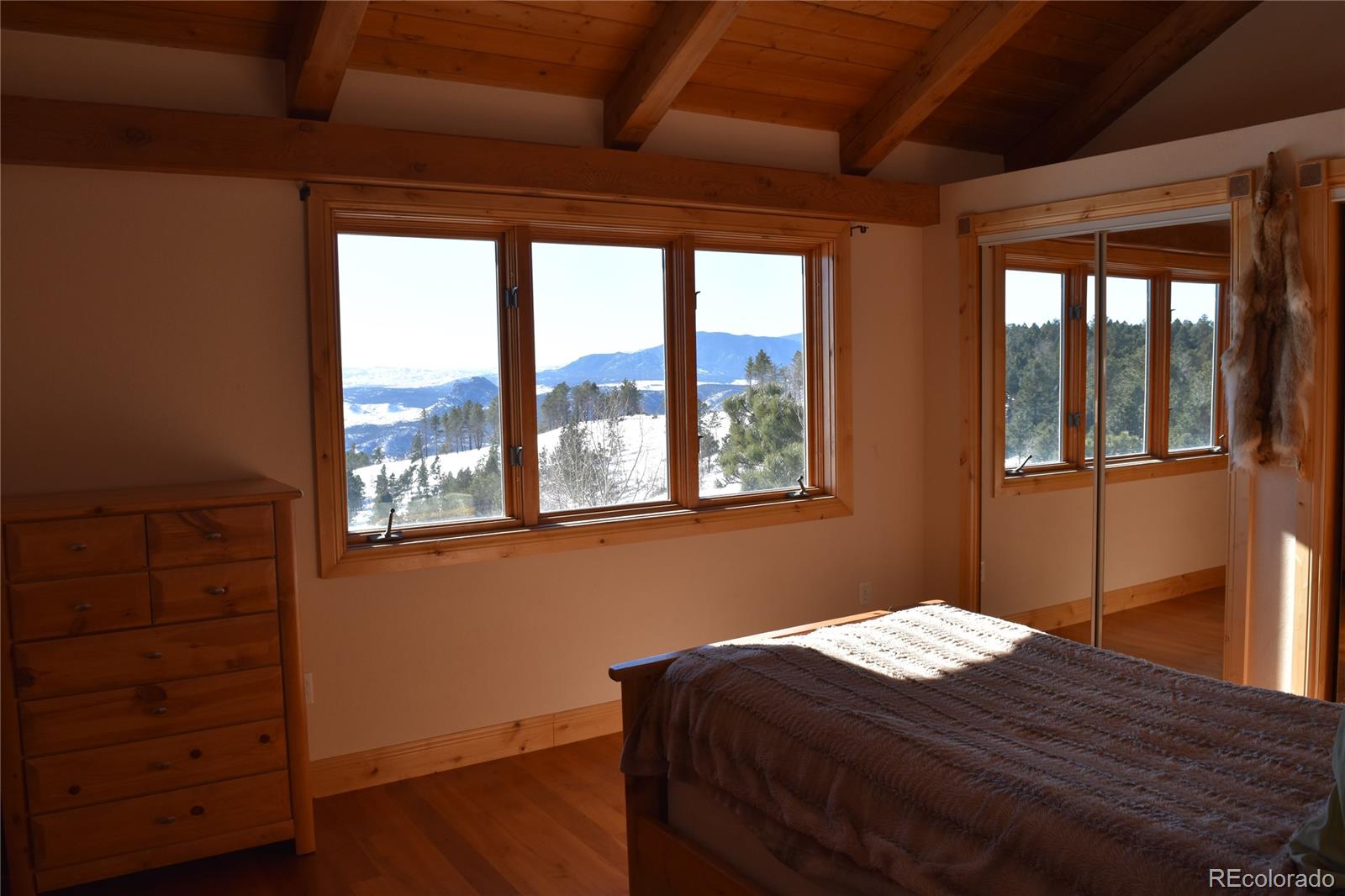 16750 Elk Ridge Road Littleton, CO 80127 - Photo 11 of 25 a bedroom with a bed and wooden floor