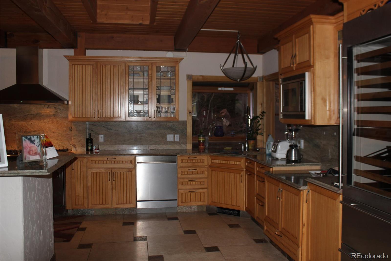 16750 Elk Ridge Road Littleton, CO 80127 - Photo 4 of 25 a kitchen with granite countertop a stove and a sink