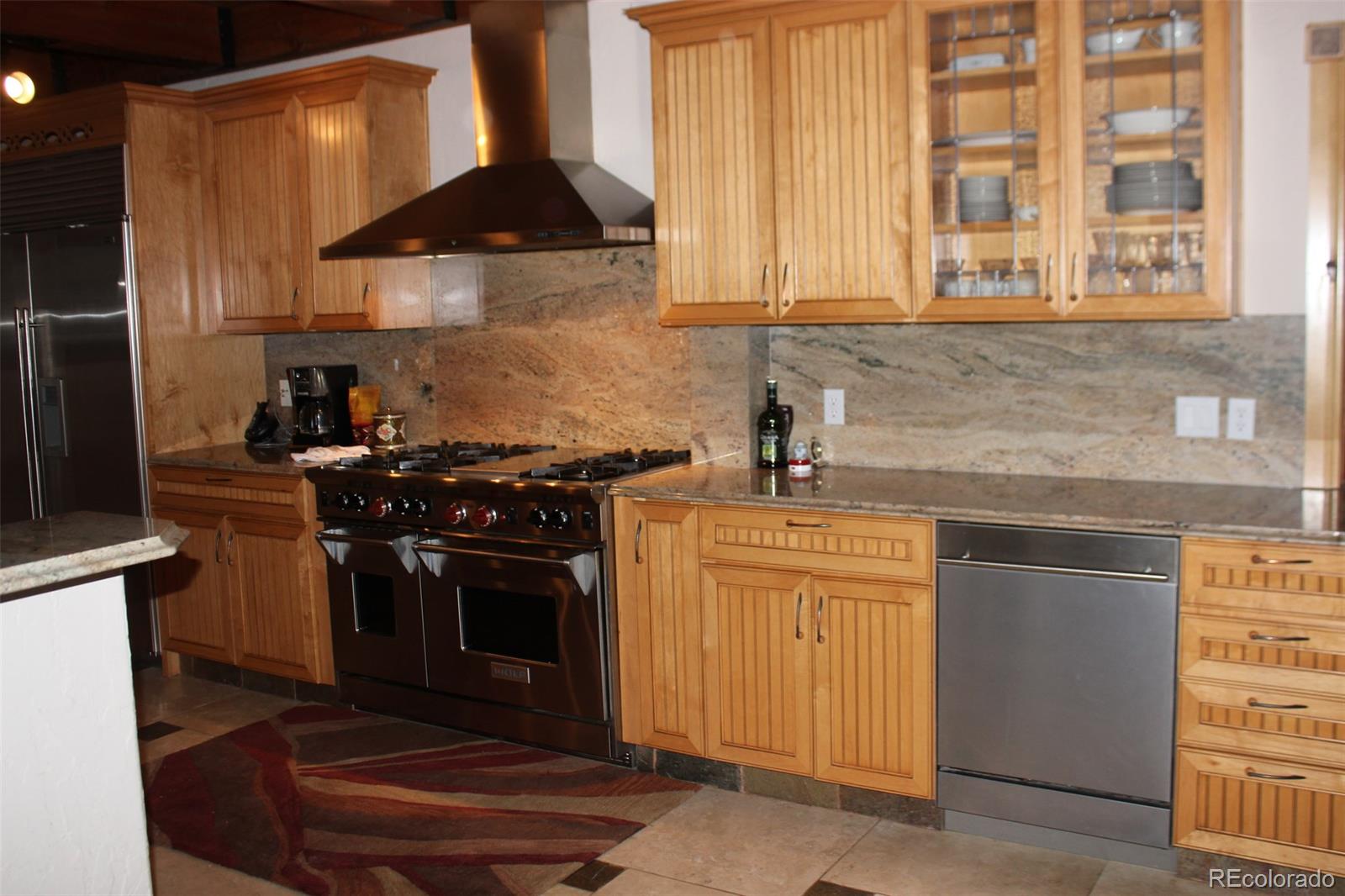 16750 Elk Ridge Road Littleton, CO 80127 - Photo 6 of 25 a kitchen with stainless steel appliances a stove a sink and a microwave