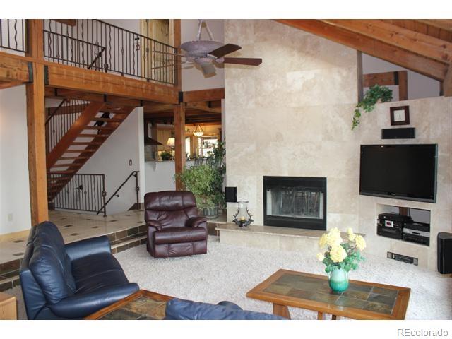 16750 Elk Ridge Road Littleton, CO 80127 - Photo 8 of 25 a living room with furniture a fireplace and a flat screen tv
