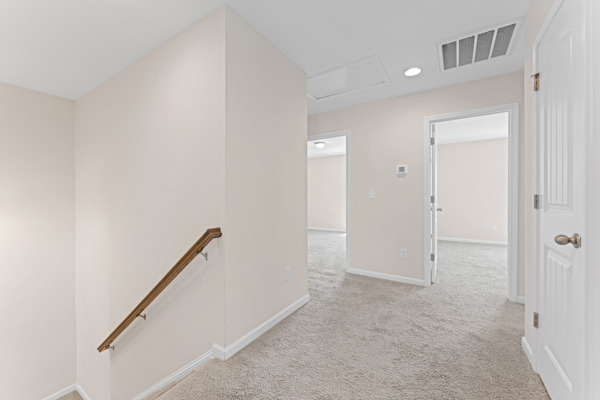 249 Samuel Street Pendleton, SC 29670 - Photo 23 of 33 This bright hallway offers a welcoming transition between living spaces with soft carpeting. Picture shows Bedroom @2 and #3 and hall closet door. Laundry room is on the left just past the staircase. The main bathroom is on the right just after that hall closet door. Master is to the right when you come up the stairs.