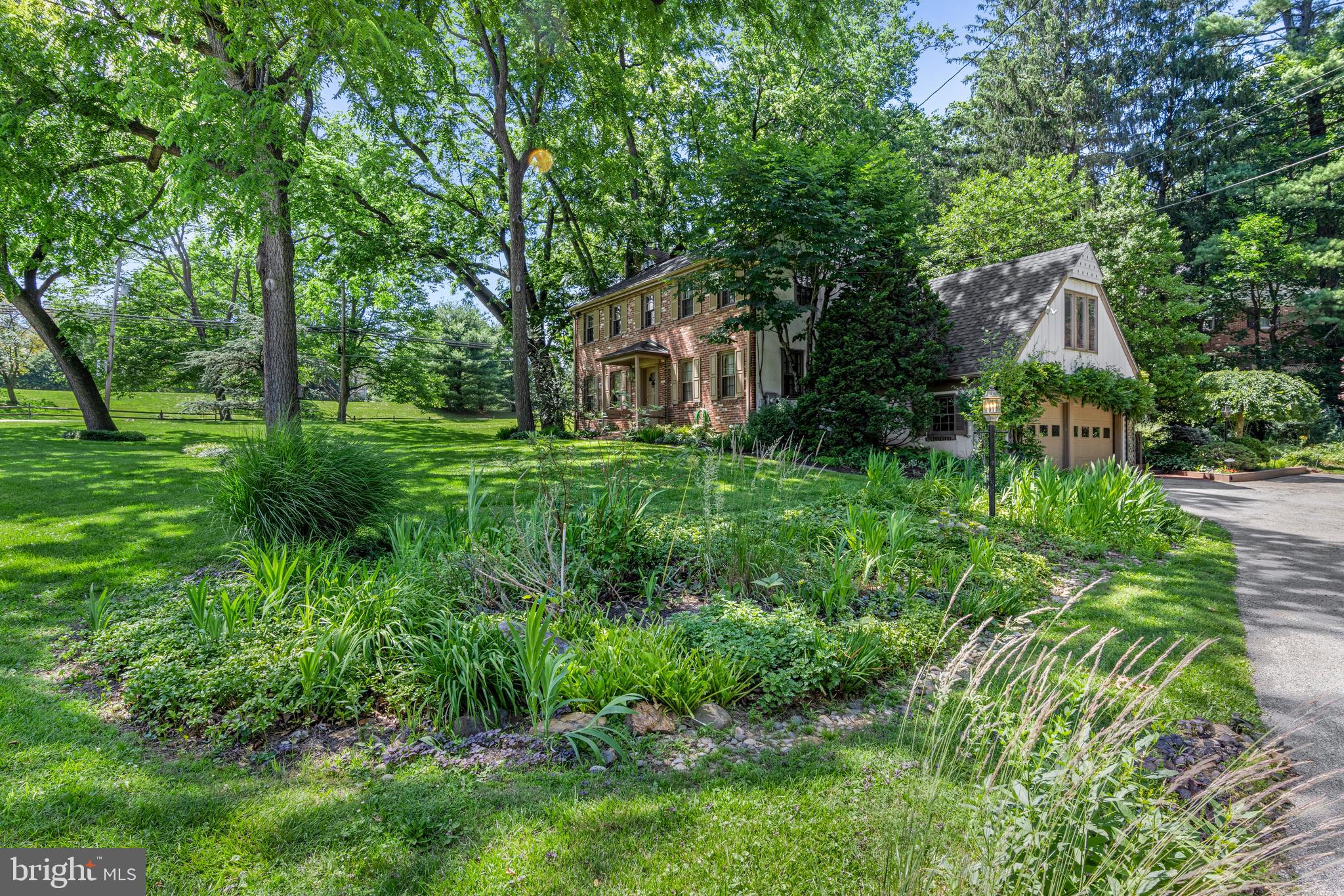 931 Hollow Road Wayne, PA 19087 - Photo 36 of 41 a backyard of a house with plants and large trees