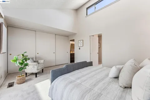 a bedroom with a bed and a large window