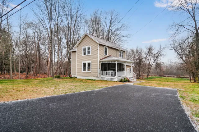 a front view of a house with a yard and trees