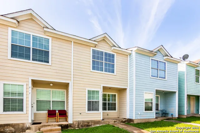 a front view of a house with a yard and a ceiling fan