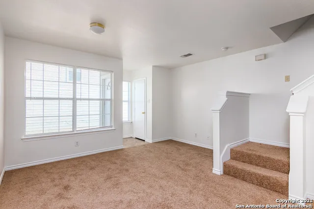 an empty room with staircase and white walls