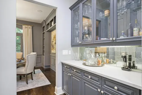 a kitchen with a sink dishwasher a dining table and chairs with wooden floor