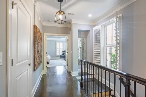 a view of a hallway view with living room and wooden floor