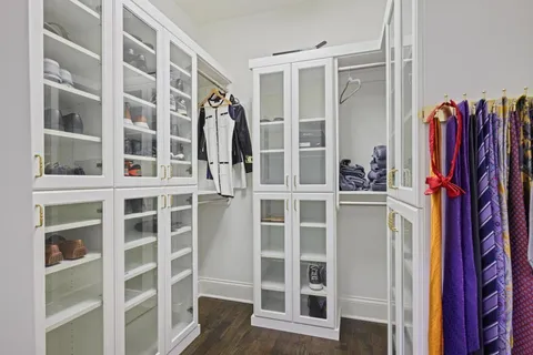 a view of walk in closet with clothes and shoes