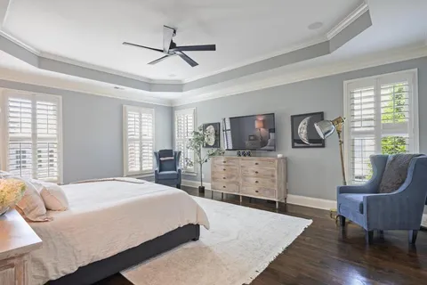 a bedroom with a bed a couch and large window